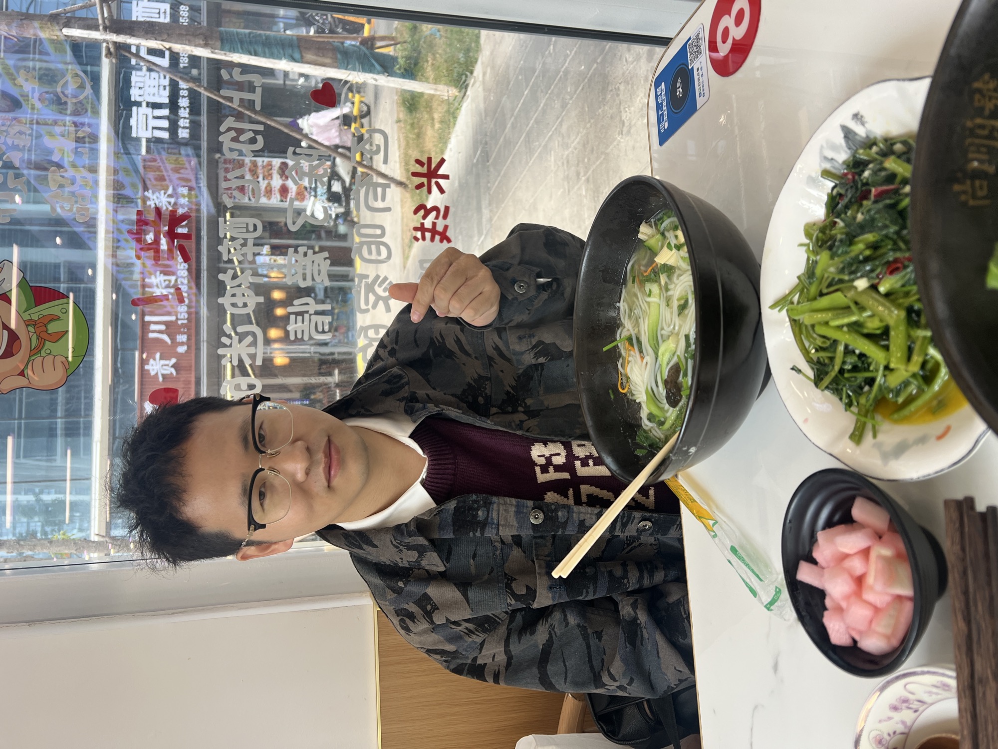 在领在小馆子里指着一大碗米线